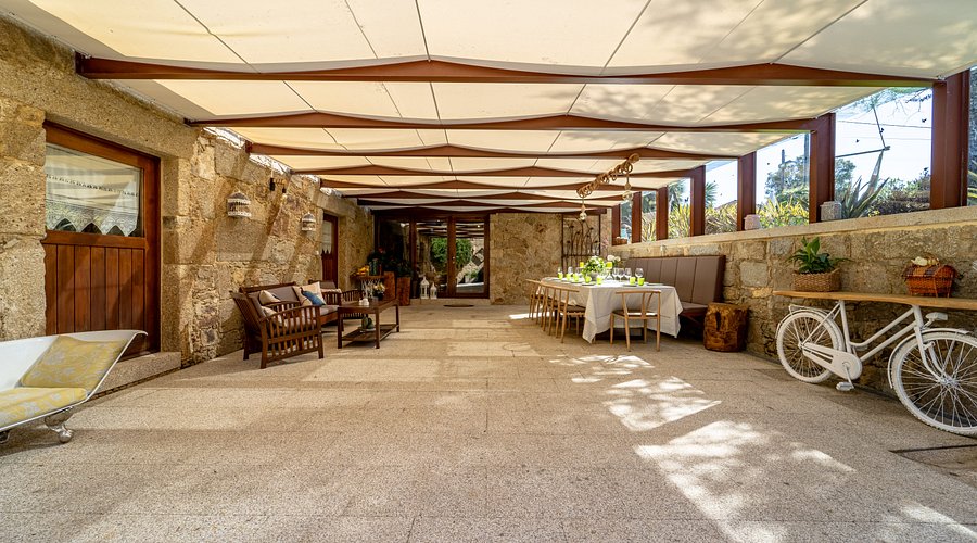 Mesa posta sob o pérgola para um evento na quinta